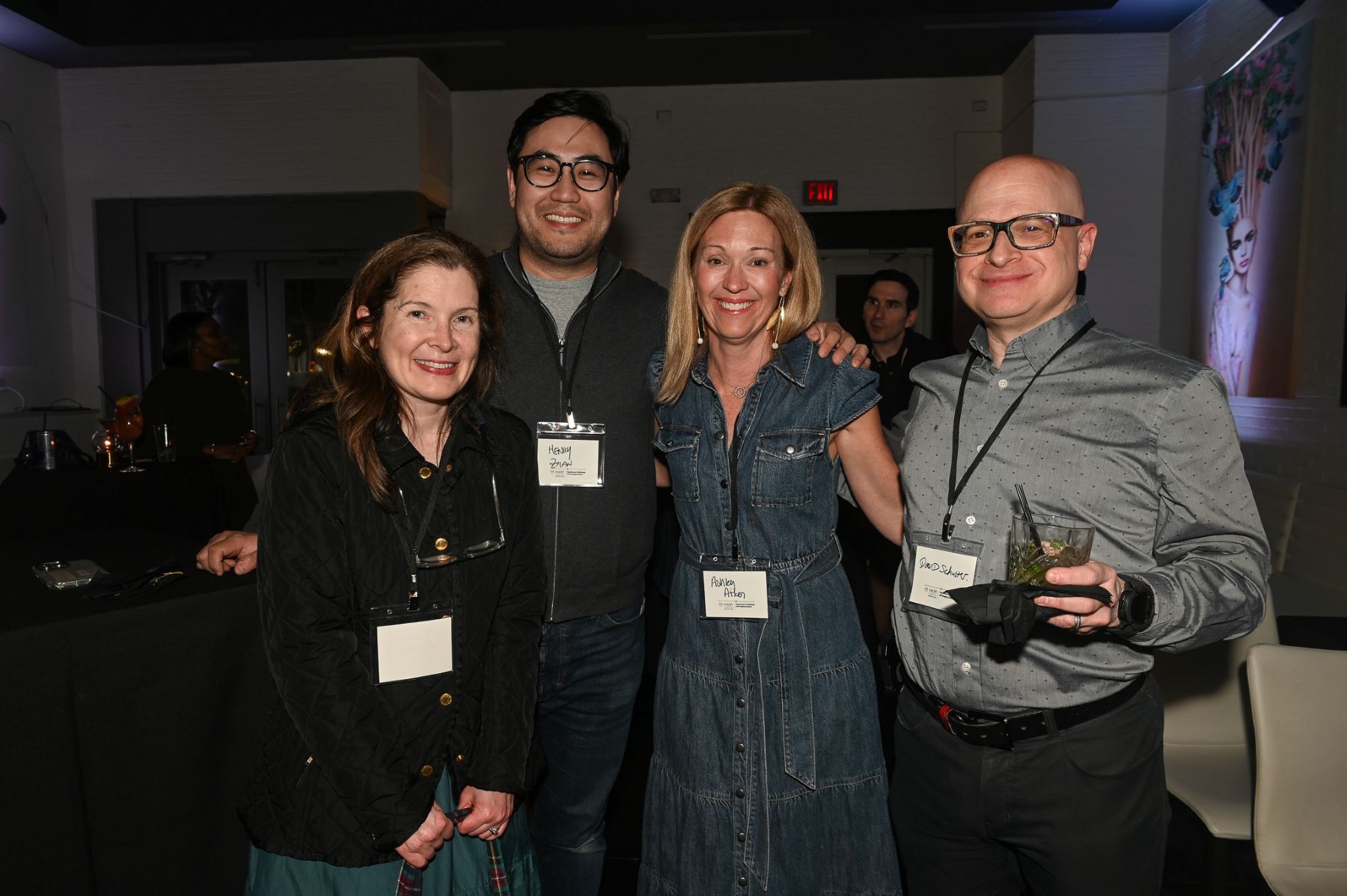 four people smiling at a party