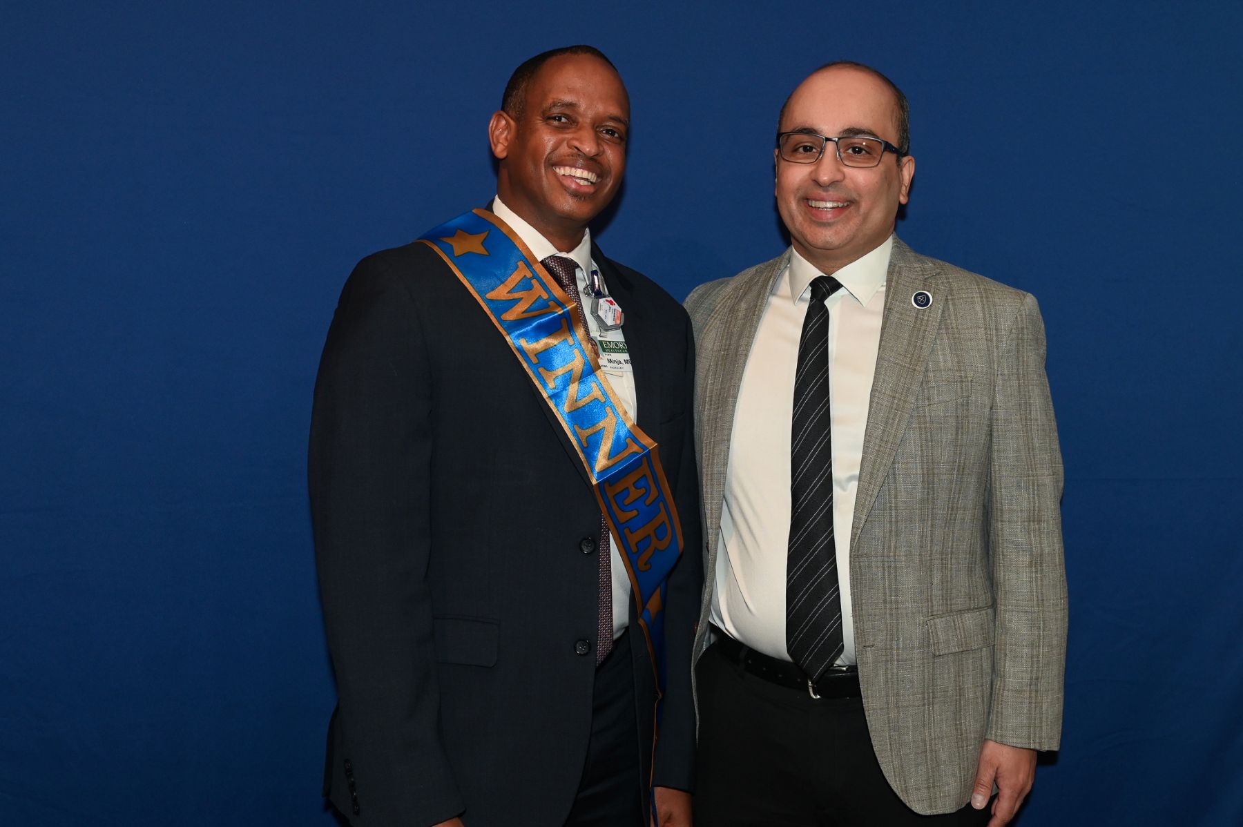 two people smiling one wearing winner sash