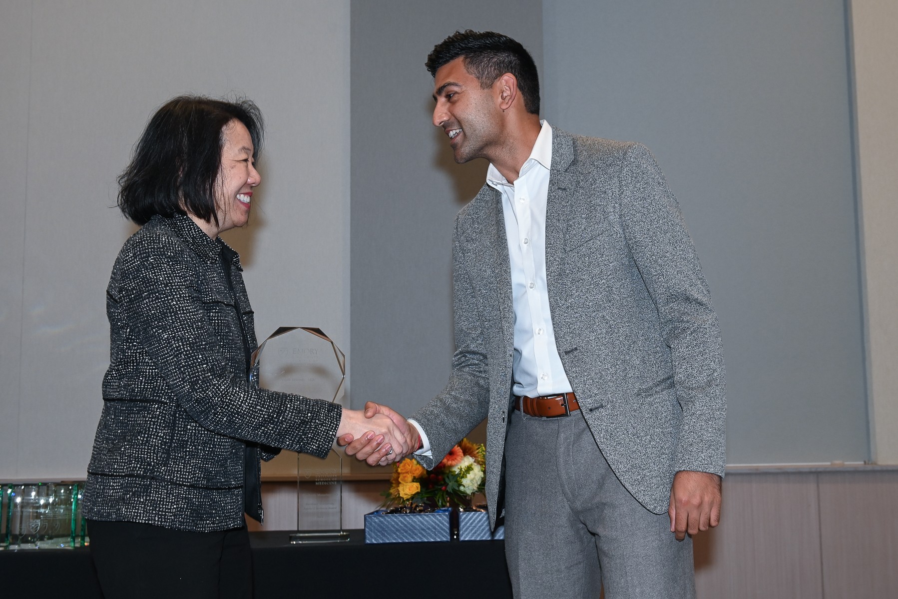 two people shaking hands and smiling at each other
