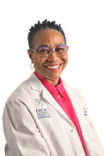 smiling person wearing glasses and a white doctor coat