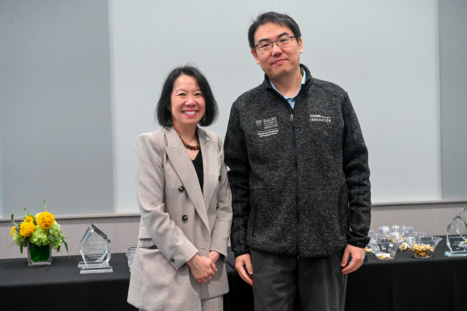 two scientists standing side-by-side smiling