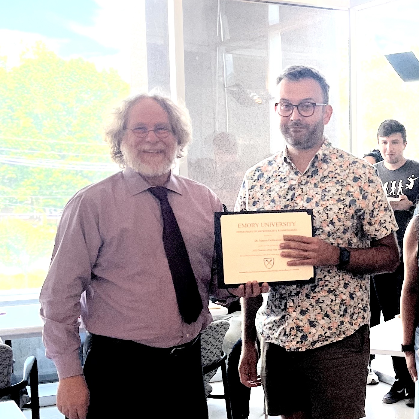 two men standing with one holding certificate