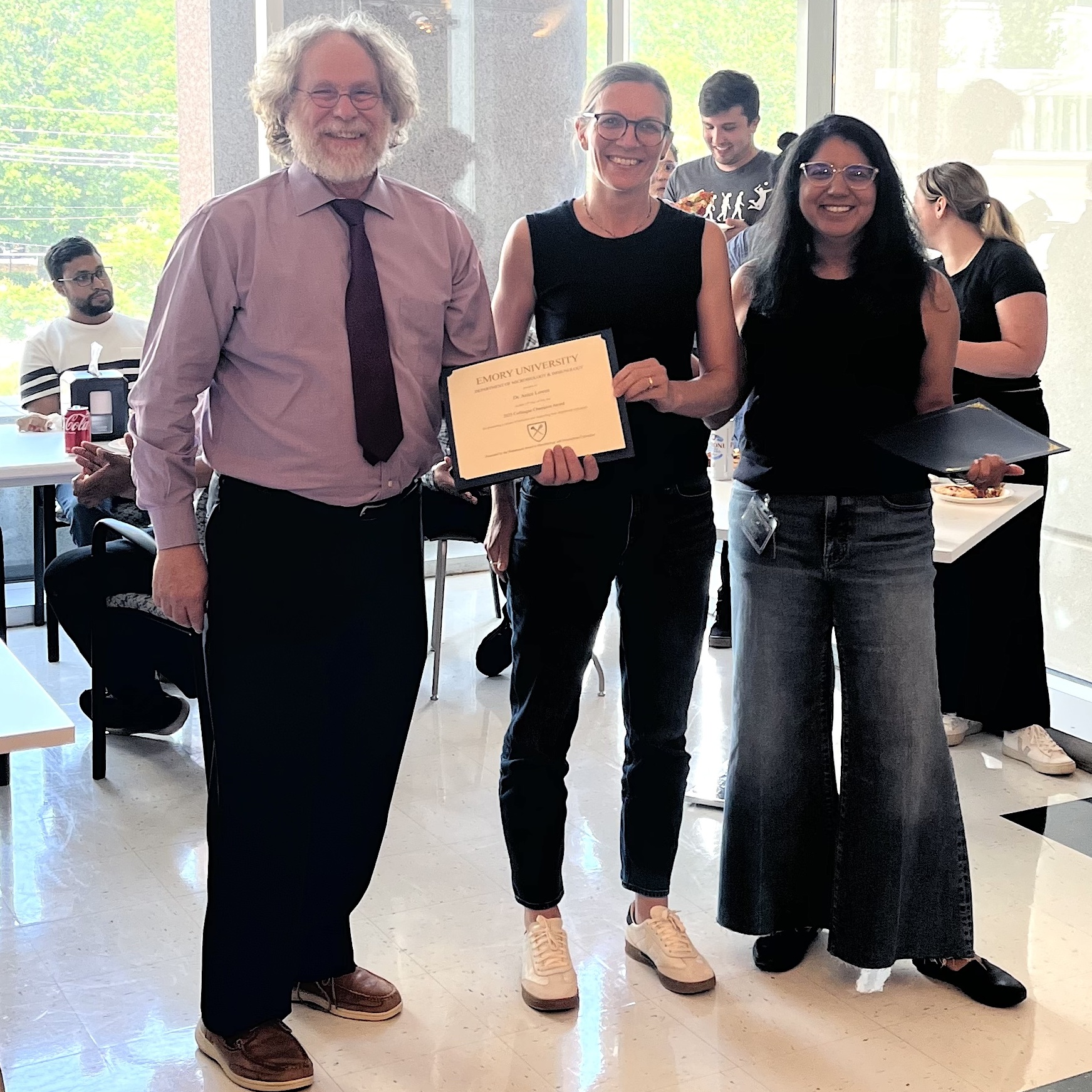 Three people standing at award ceremony
