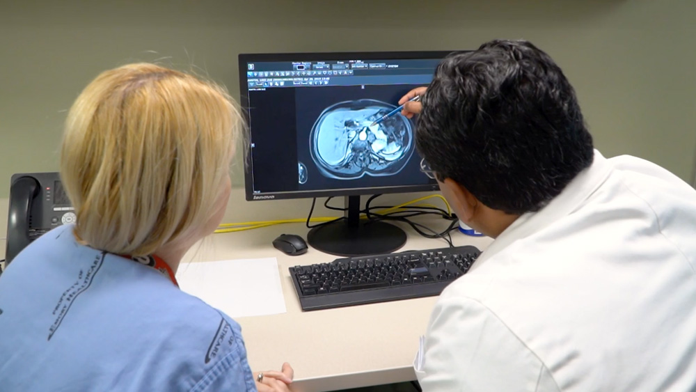 Dr. Joes Sharma and a physician assistant viewing imaging.