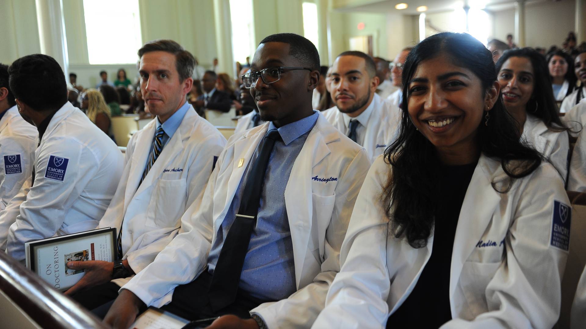 Students seated in white coats