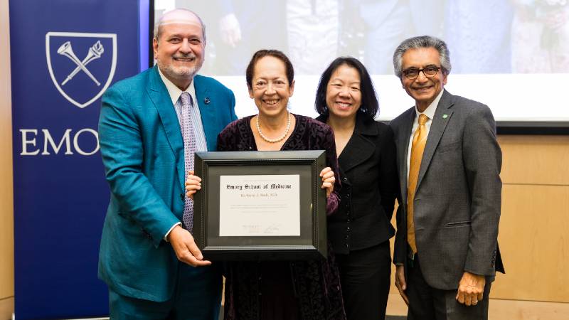 4 people smiling for the camera holding a certificate