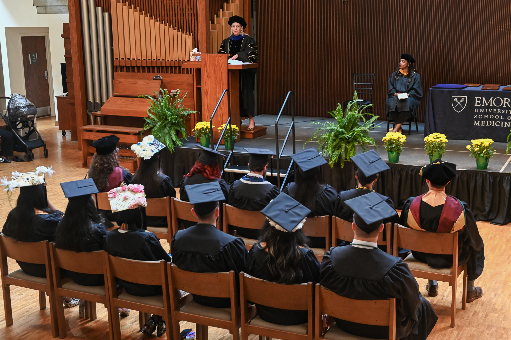Medical Imaging graduates sit in caps and gowns, awaiting ceremony.