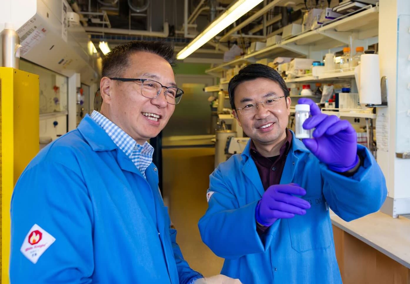 Mingji Dai, right, holds a vial of the synthesized compound alongside collaborator Yong Wan.