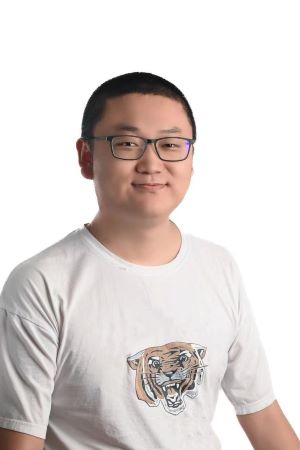 smiling person wearing spectacles and a shirt with a tiger face across the chest